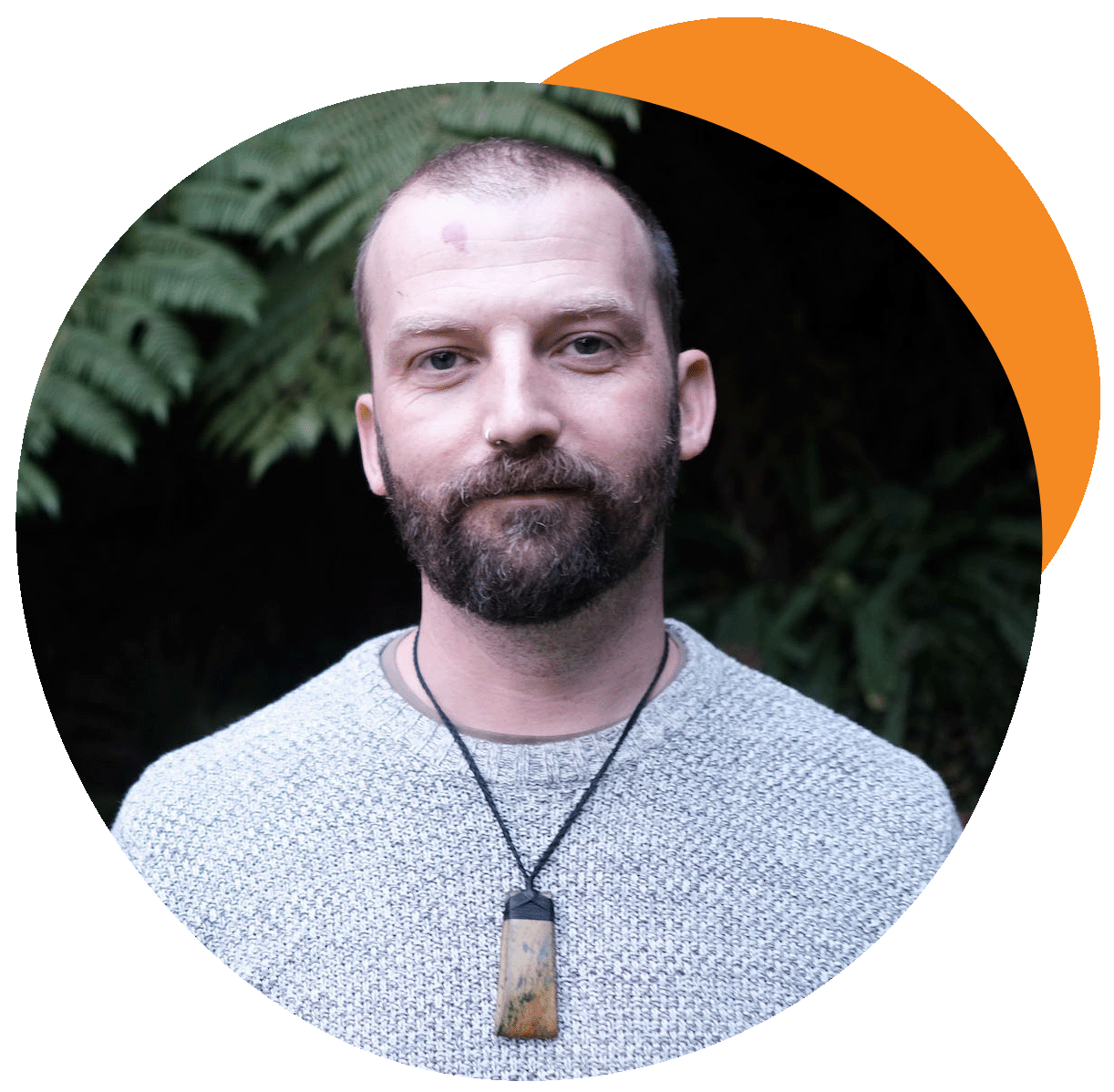 A picture of Lee, smiling, with a backdrop of native plants
