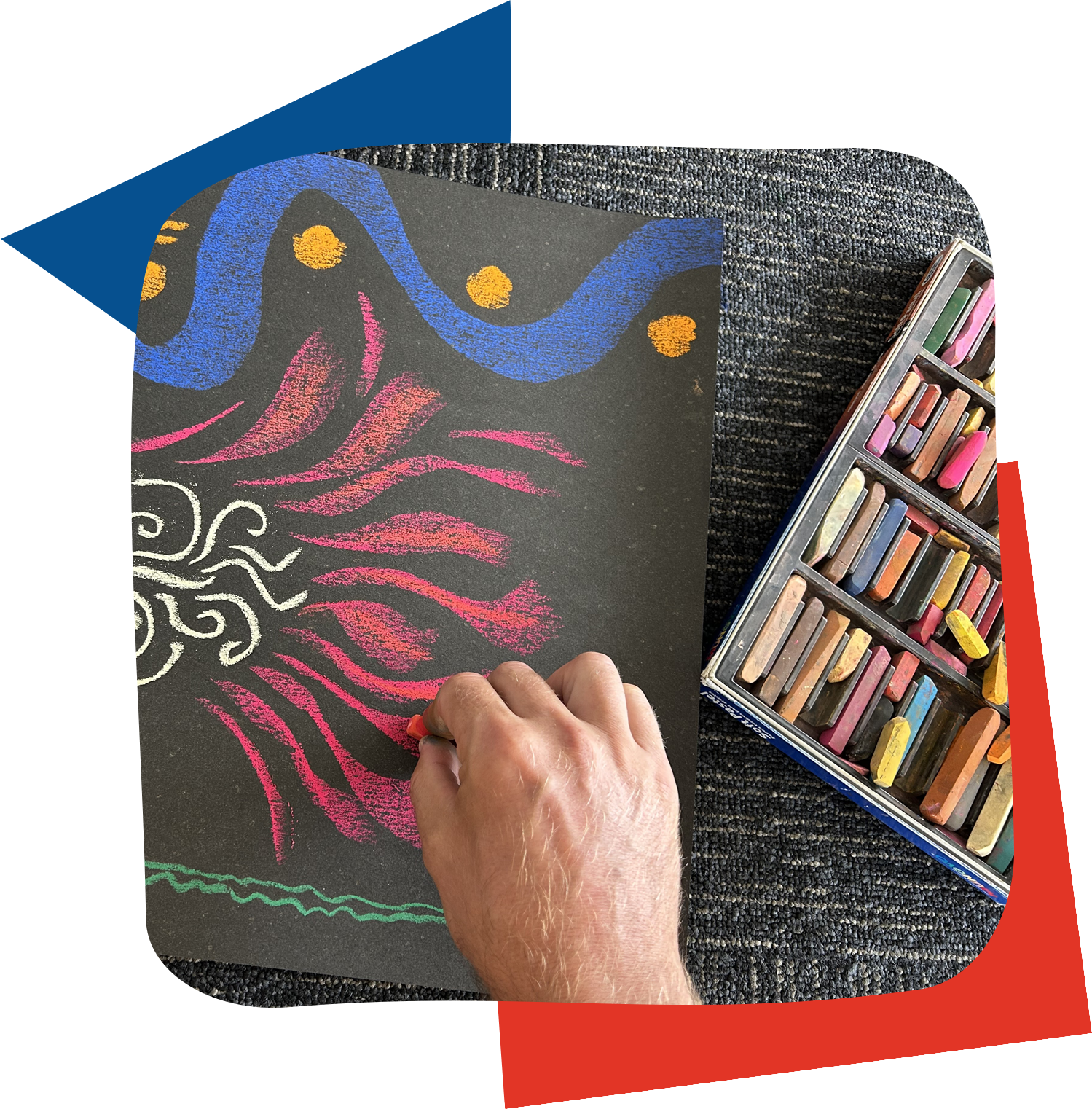 a hand drawing bright coloured abstract shapes on black paper using soft pastels